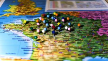 Une carte de la France avec des punaises colorées marquant différentes destinations.
