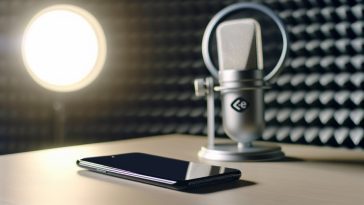 Un smartphone posé sur une table avec un micro à côté, symbolisant l'écoute.