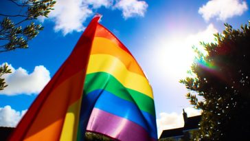 Un drapeau arc-en-ciel, symbole de la communauté LGBTQIA+, flottant au vent.