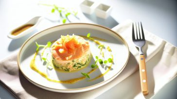 Une blanquette de saumon bien présentée dans une assiette, avec une fourchette à côté prête à déguster.
