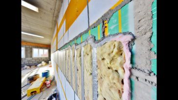Un mur en cours d'isolation thermique avec des plaques de doublage.