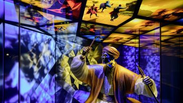 Un homme en costume noir, regardant fixement la caméra avec un air sérieux et déterminé.