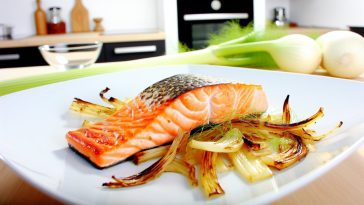 Des pavés de saumon et du fenouil rôtis disposés de manière appétissante sur une assiette.