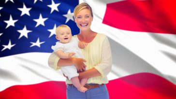 Une femme française souriante tenant un bébé dans ses bras, avec le drapeau américain en arrière-plan.