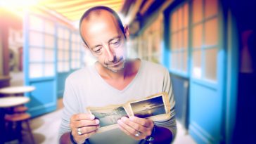 Une personne regardant pensivement une photo ancienne.